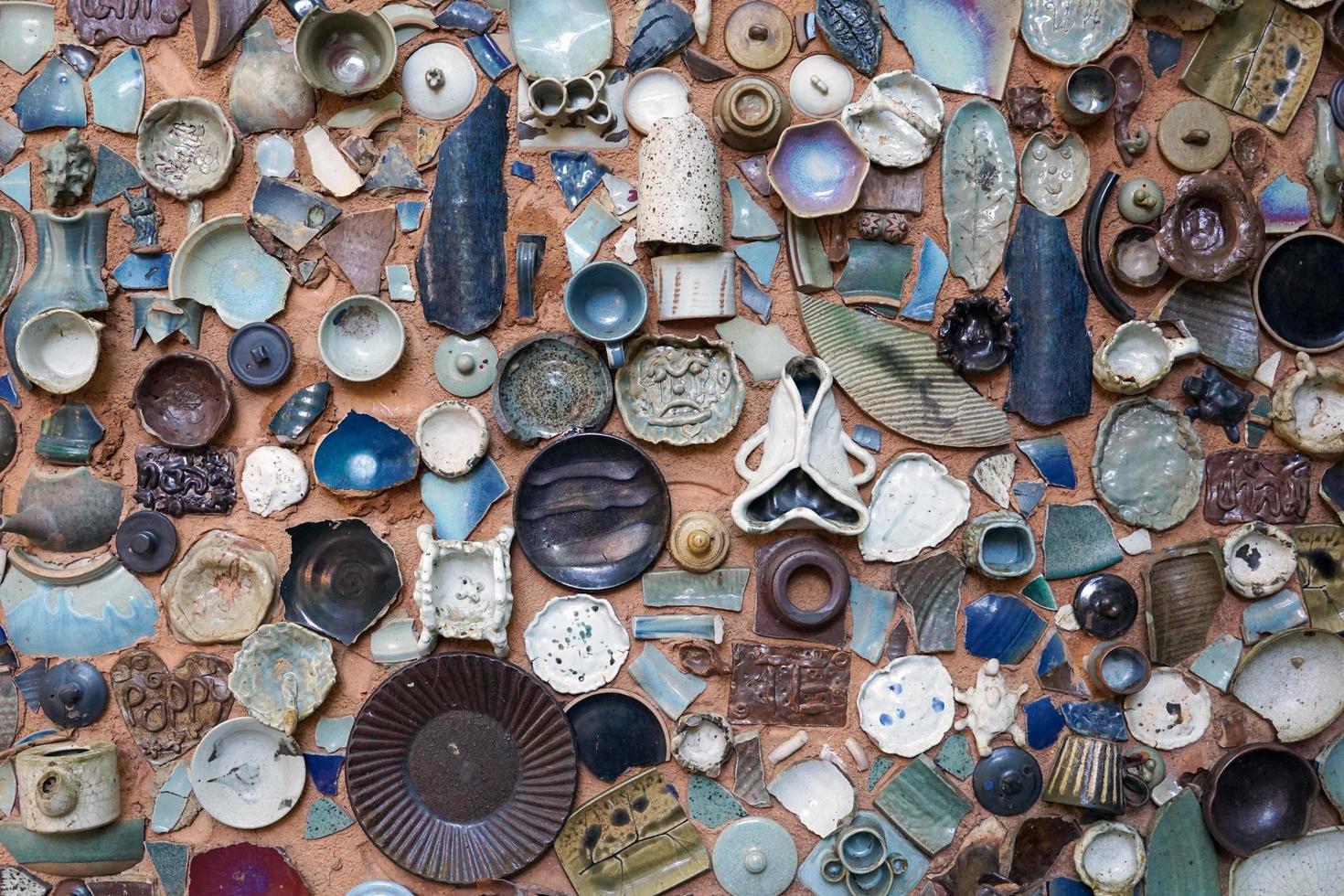 arte de pared de cemento decorado con fragmentos de tazas, platos, vasos, jarrones de terracota rotos. enfoque suave y selectivo. foto