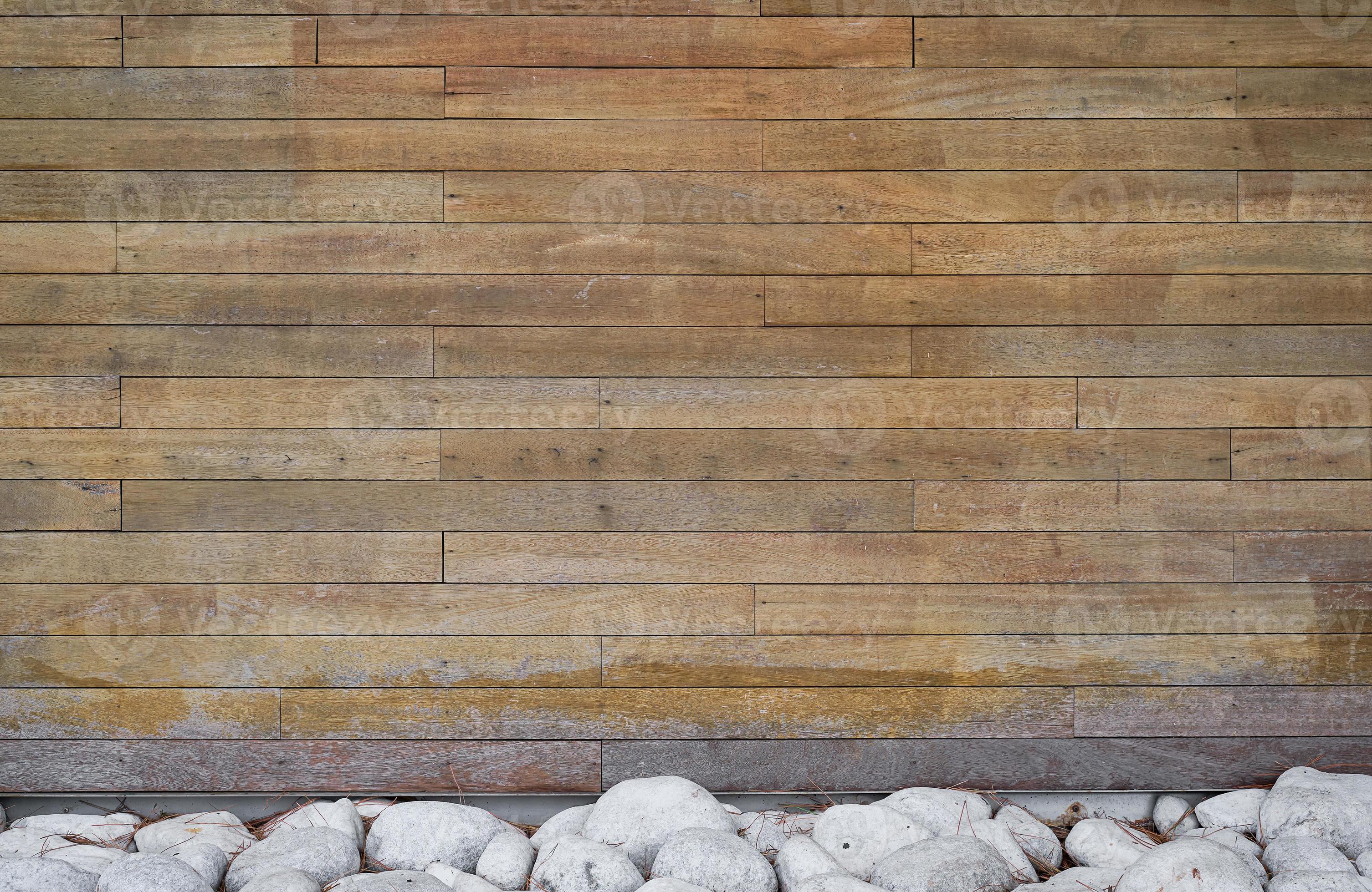 Background of boards and decor of stones on the bottom of the wall