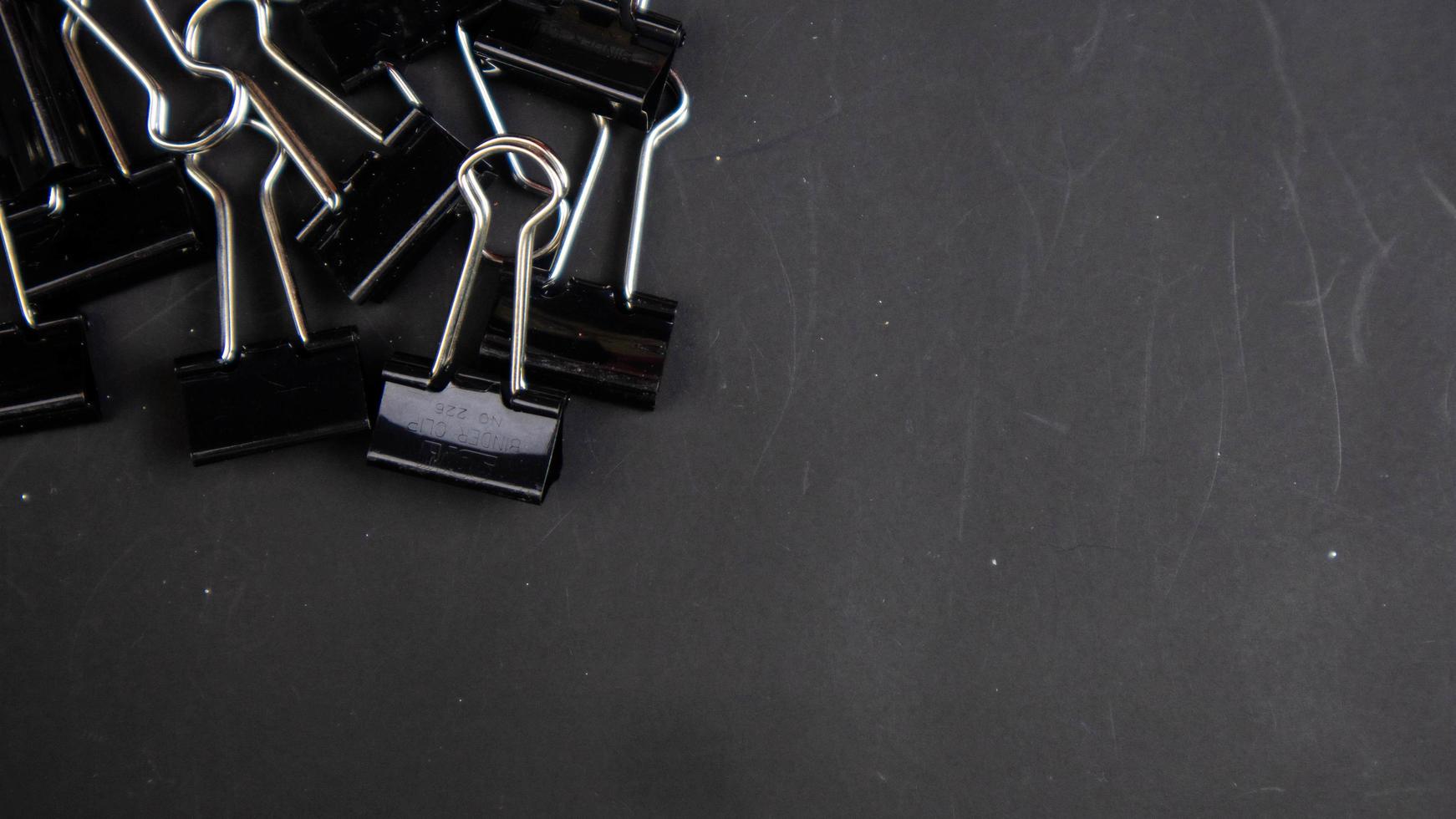 a black paper clip on a black background photo