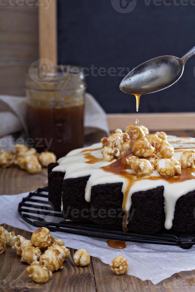 Chocolate cake with cream glaze and caramel photo