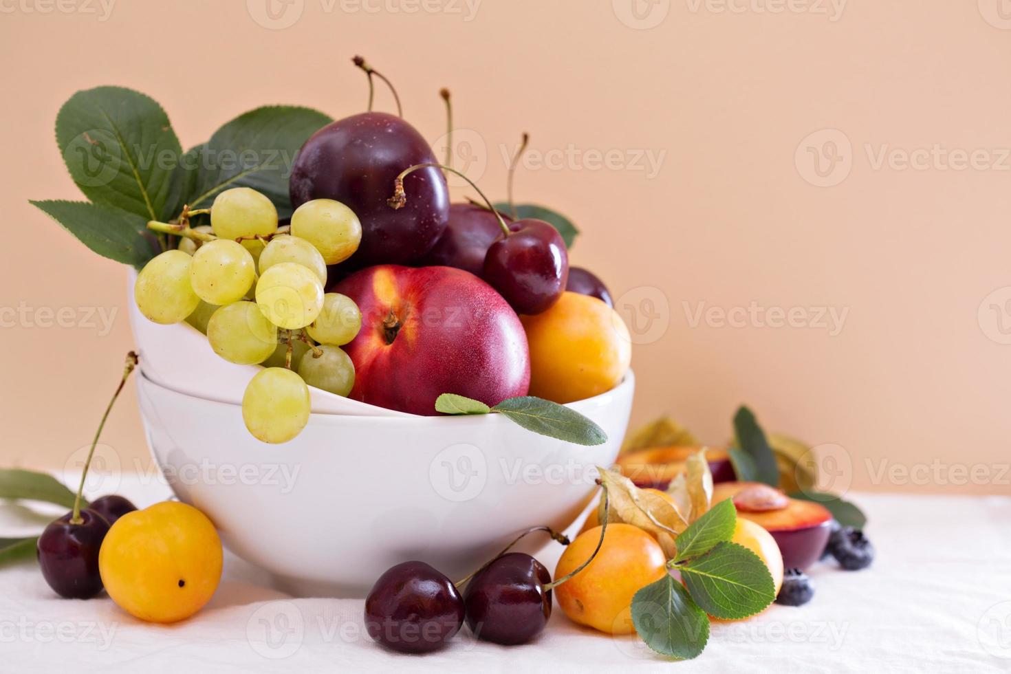 Fresh stone fruits in white bowl photo