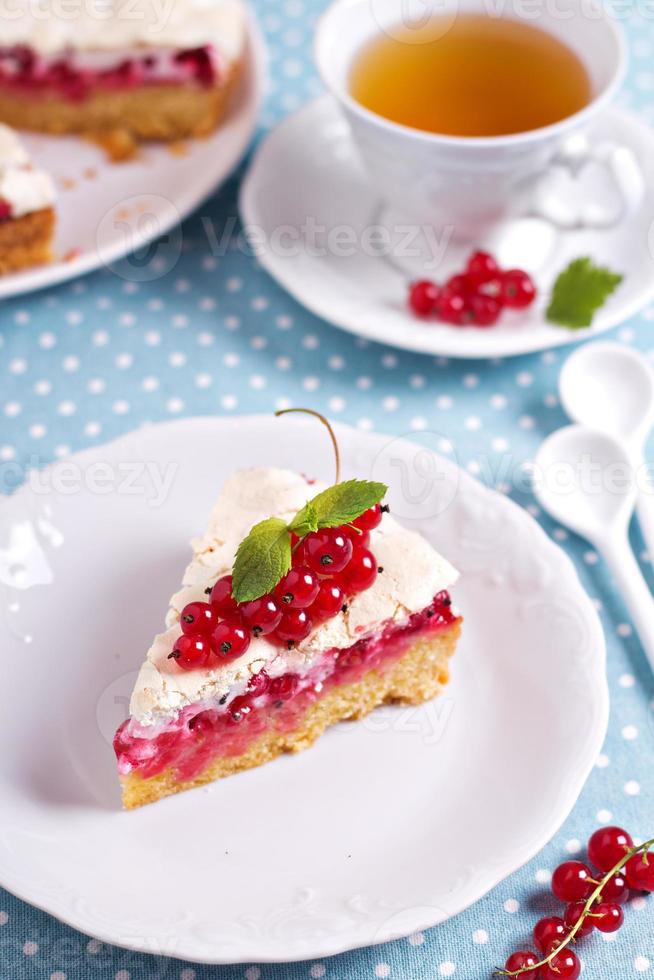 Meringue red currant cake on blue table photo
