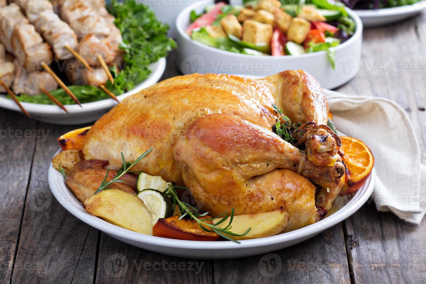 Whole roasted chicken on dinner table photo