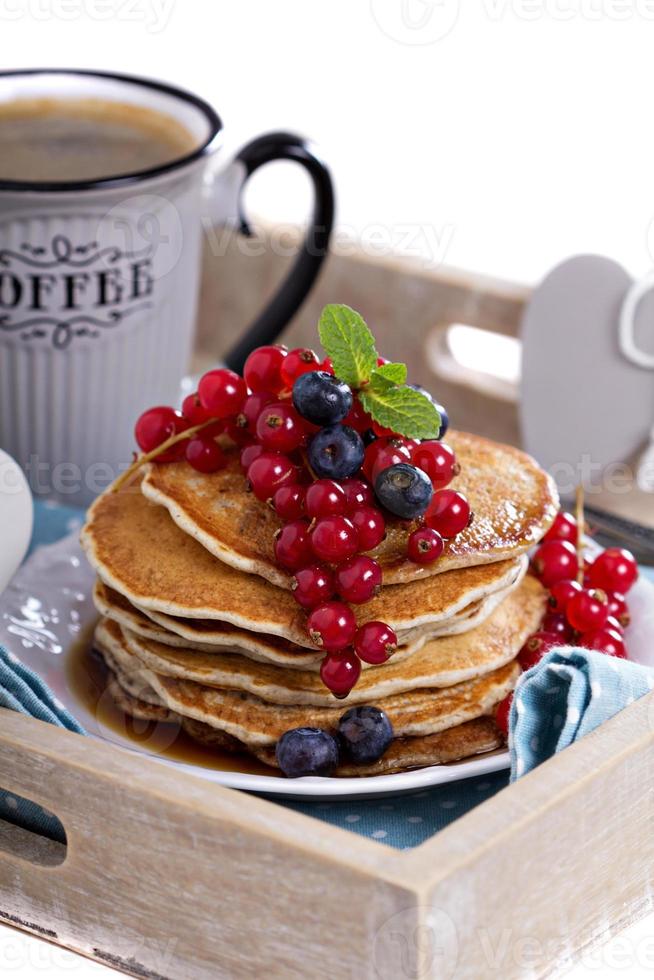 Pancakes with mixed berries isolated on white photo