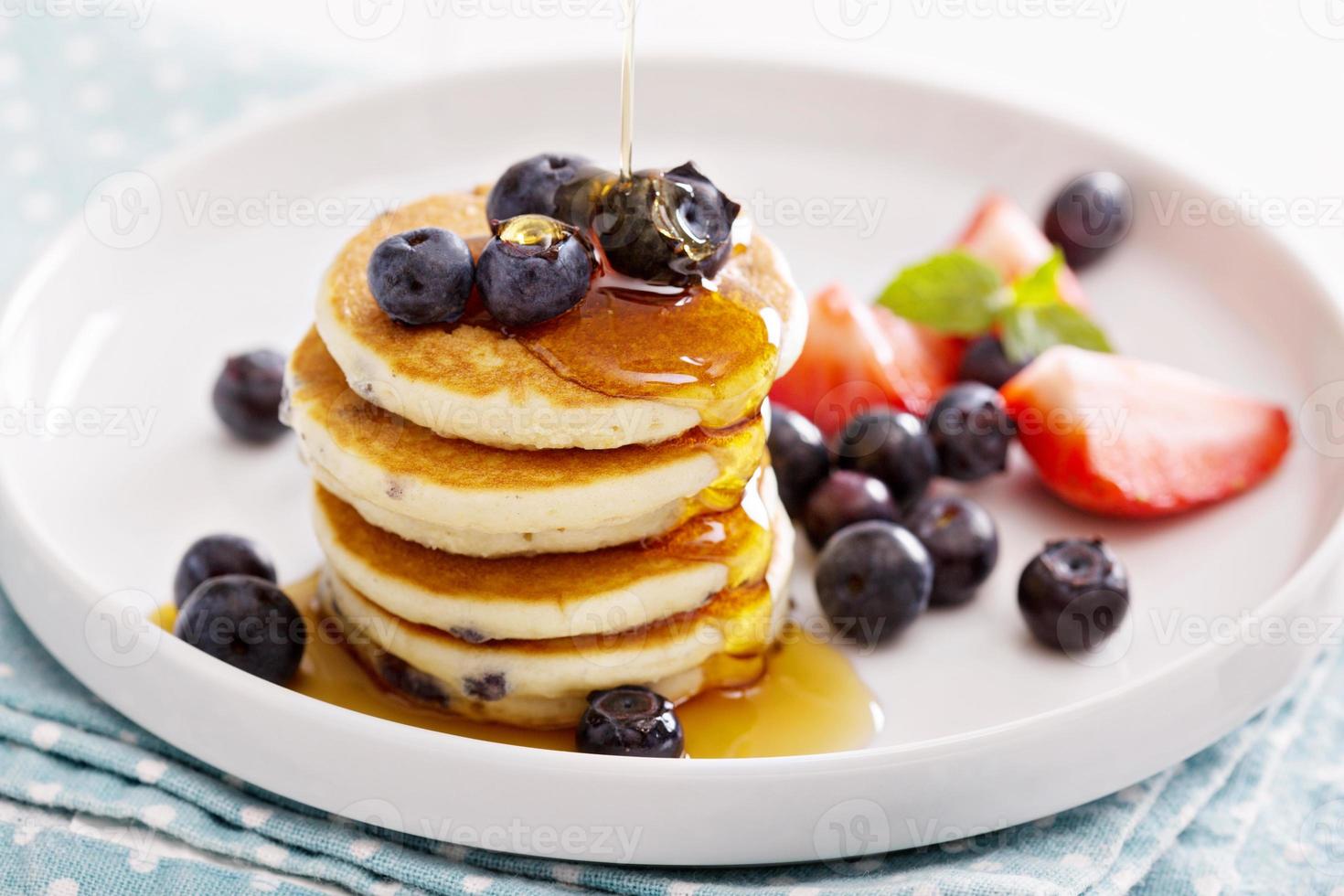 Stack of small pancakes with fresh berries photo