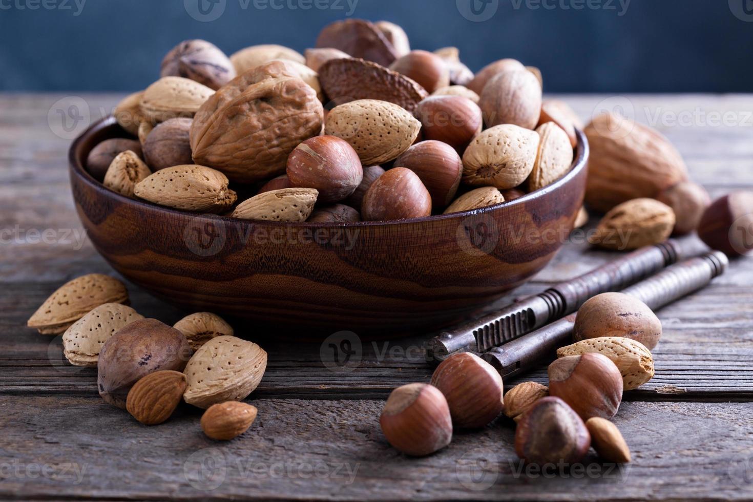 variedad de nueces con cáscara en un tazón foto