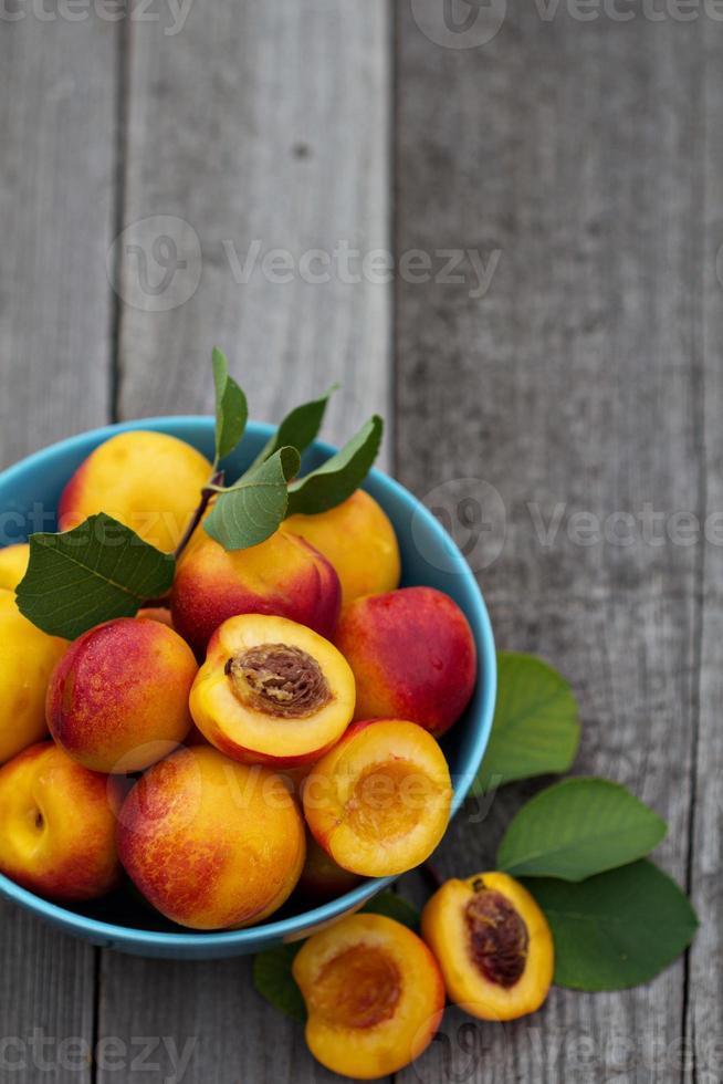 Fresh peaches in blue bowl photo