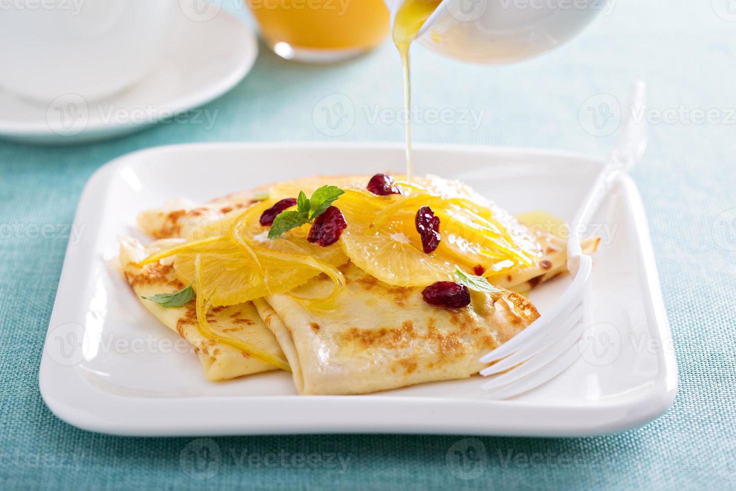 Thin crepes with citrus sauce and dried cranberry photo