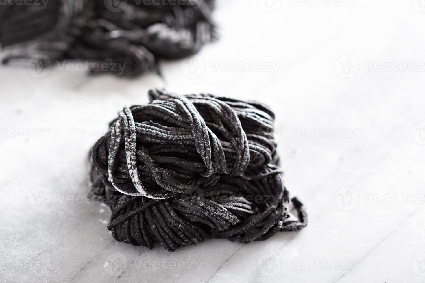 Squid ink homemade pasta on marble photo