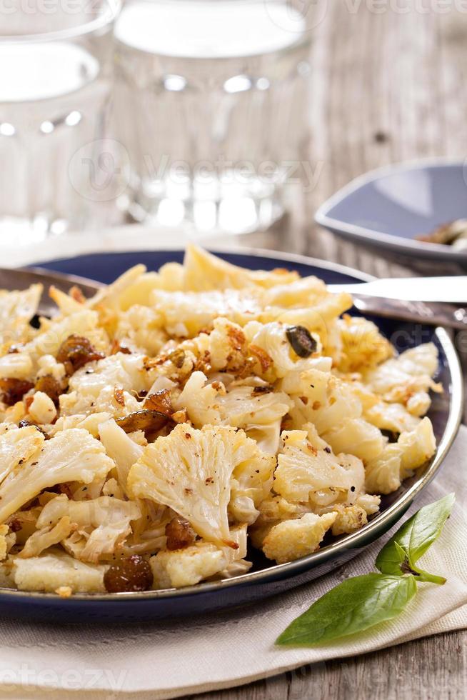 Baked cauliflower with capers and raisins photo