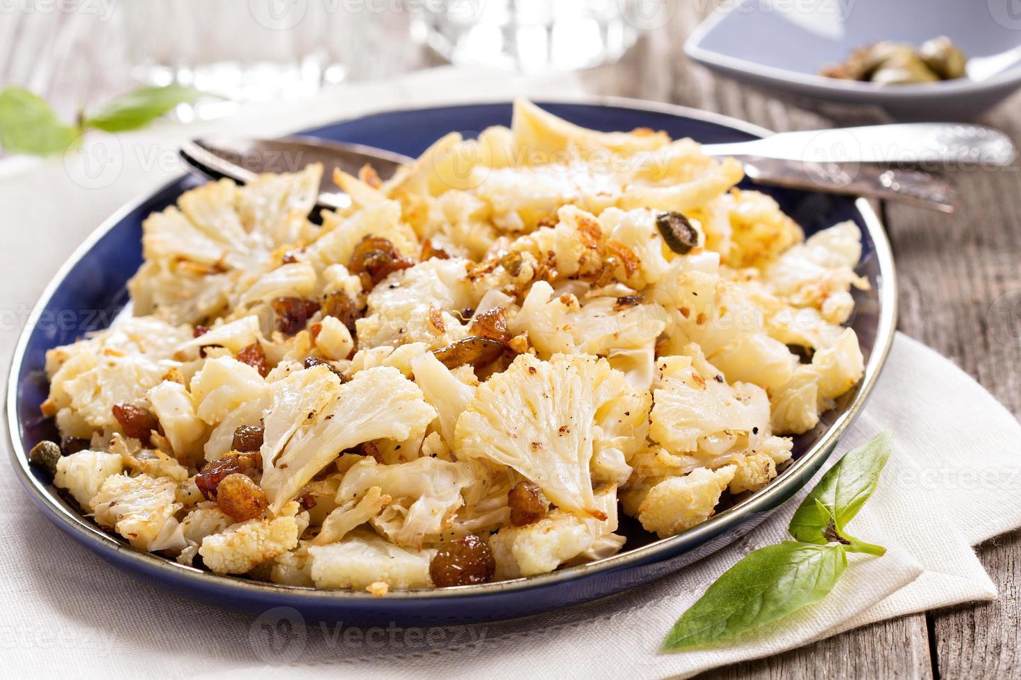 Baked cauliflower with capers and raisins photo