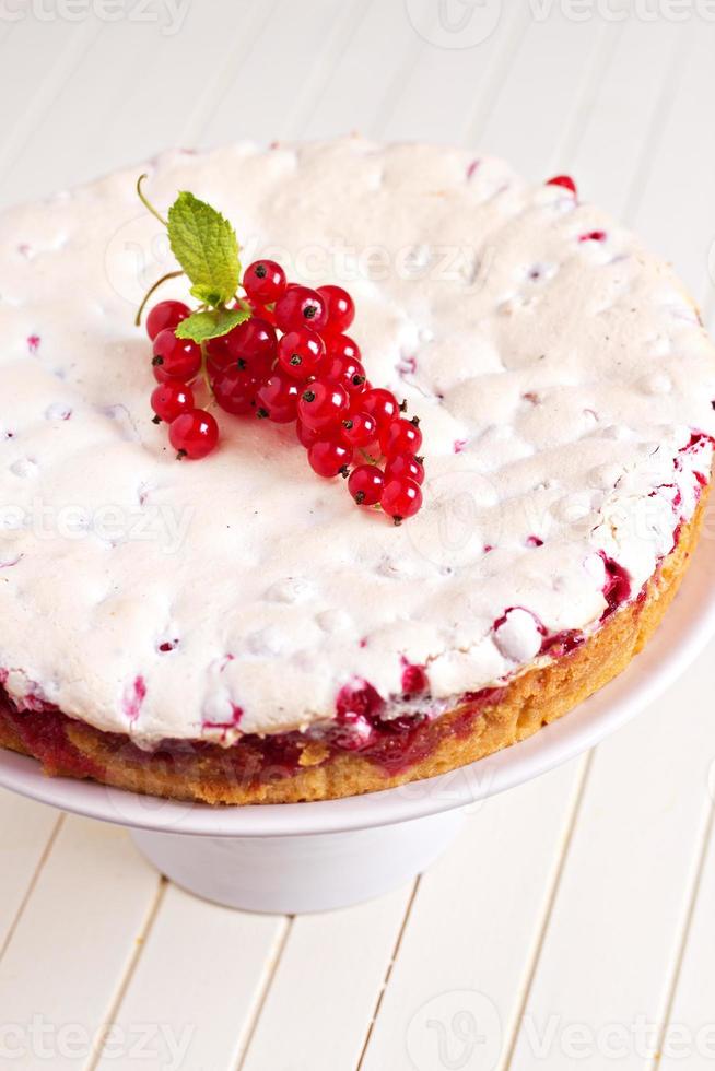 Meringue red currant cake on white table photo
