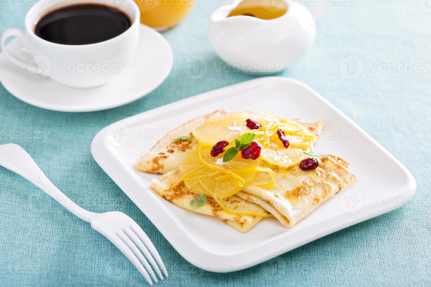 Thin crepes with citrus sauce and dried cranberry photo