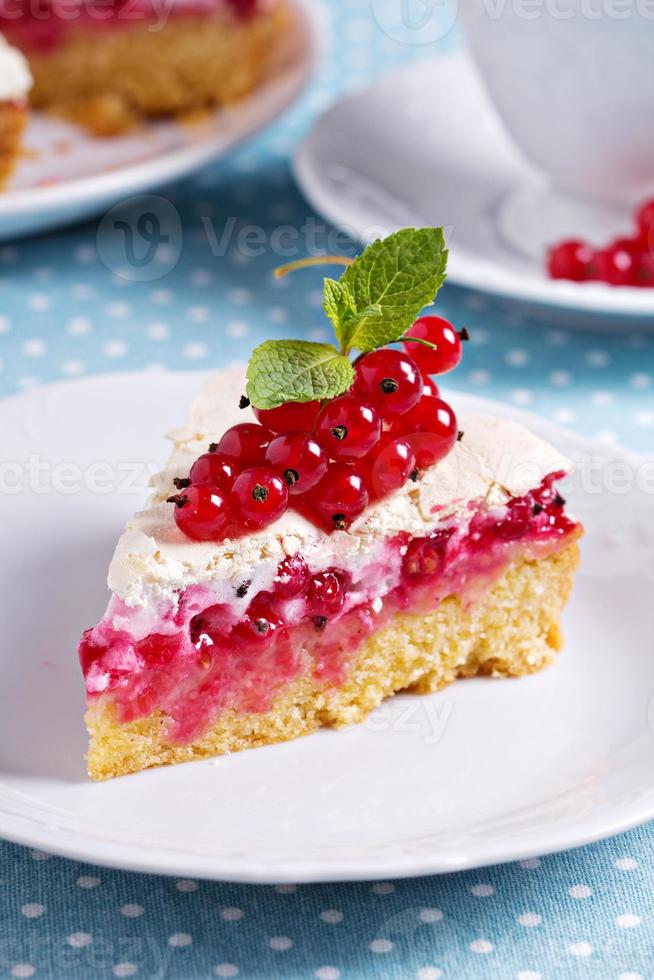 Meringue red currant cake on blue table photo