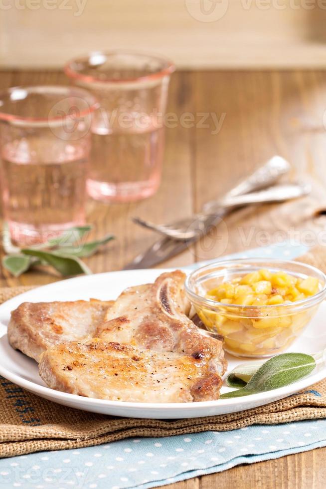 chuletas de cerdo en un hueso con chutney de manzana foto