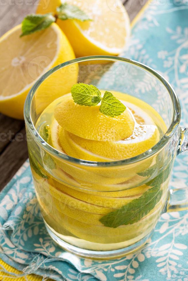 té con menta y limón entero en una taza transparente foto