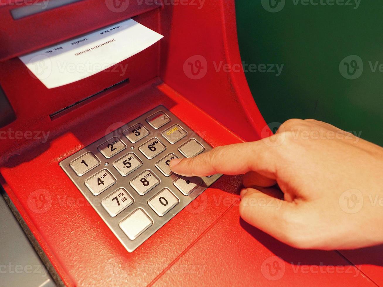 ATM button close up and paper transaction deposit pay slip and hand. photo
