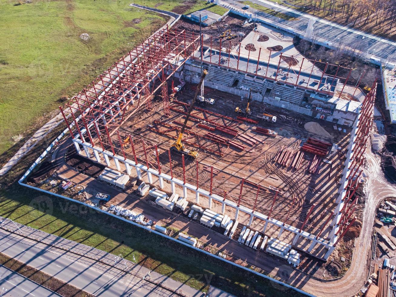 Aerial shot of construction site with metal frame and truck cranes. photo