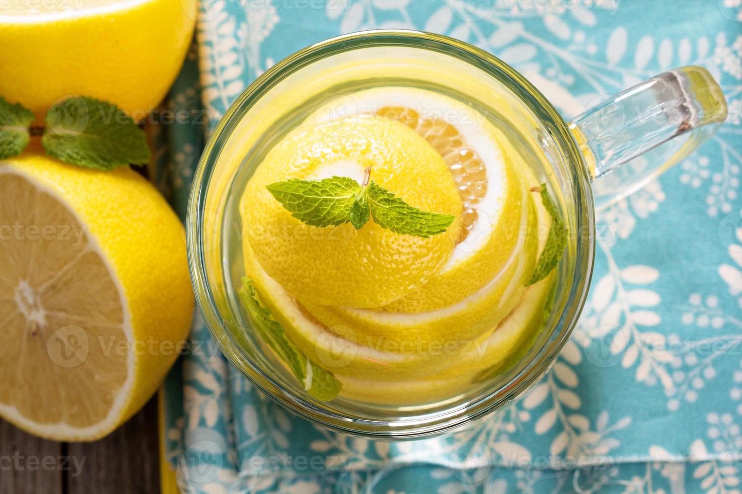 Tea with mint and whole lemon in a transparent cup photo