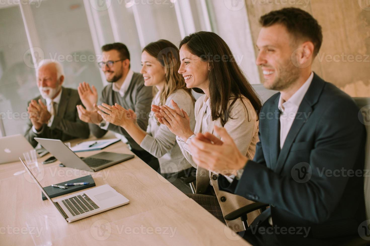 Satisfied proud business team clapping hands photo