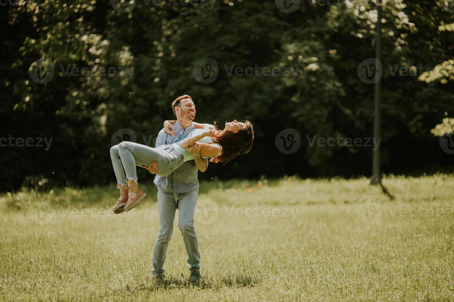 Happy young couple in love at the grass field photo