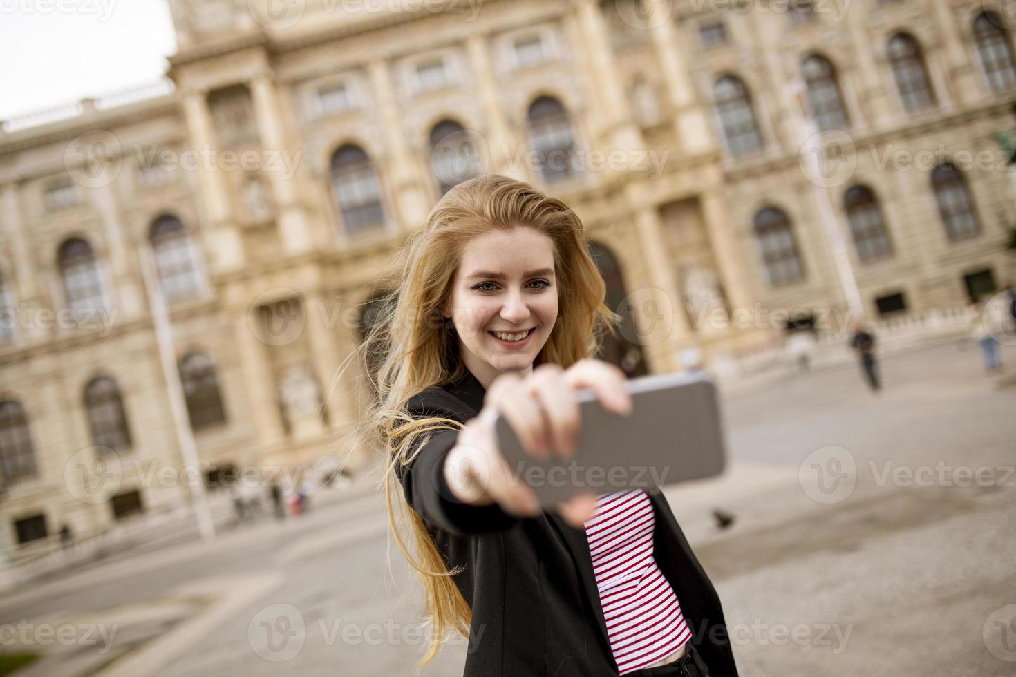 Joven turista tomando selfie con foto móvil en el centro de Viena, Austria.