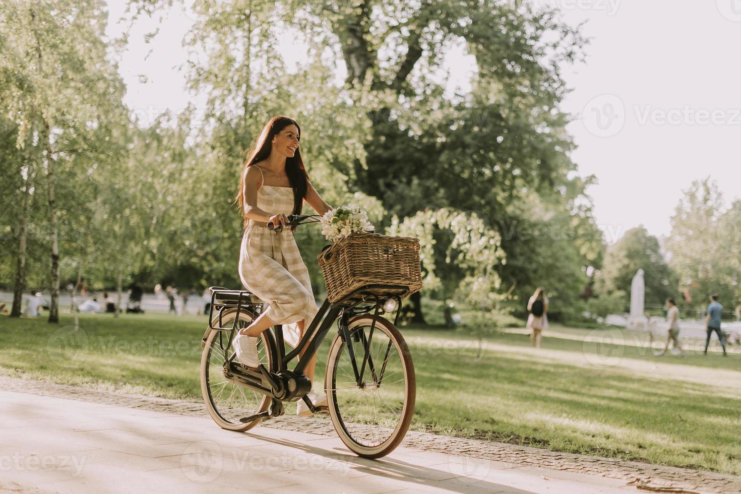 Young woman with electric bike and flowers in the basket photo