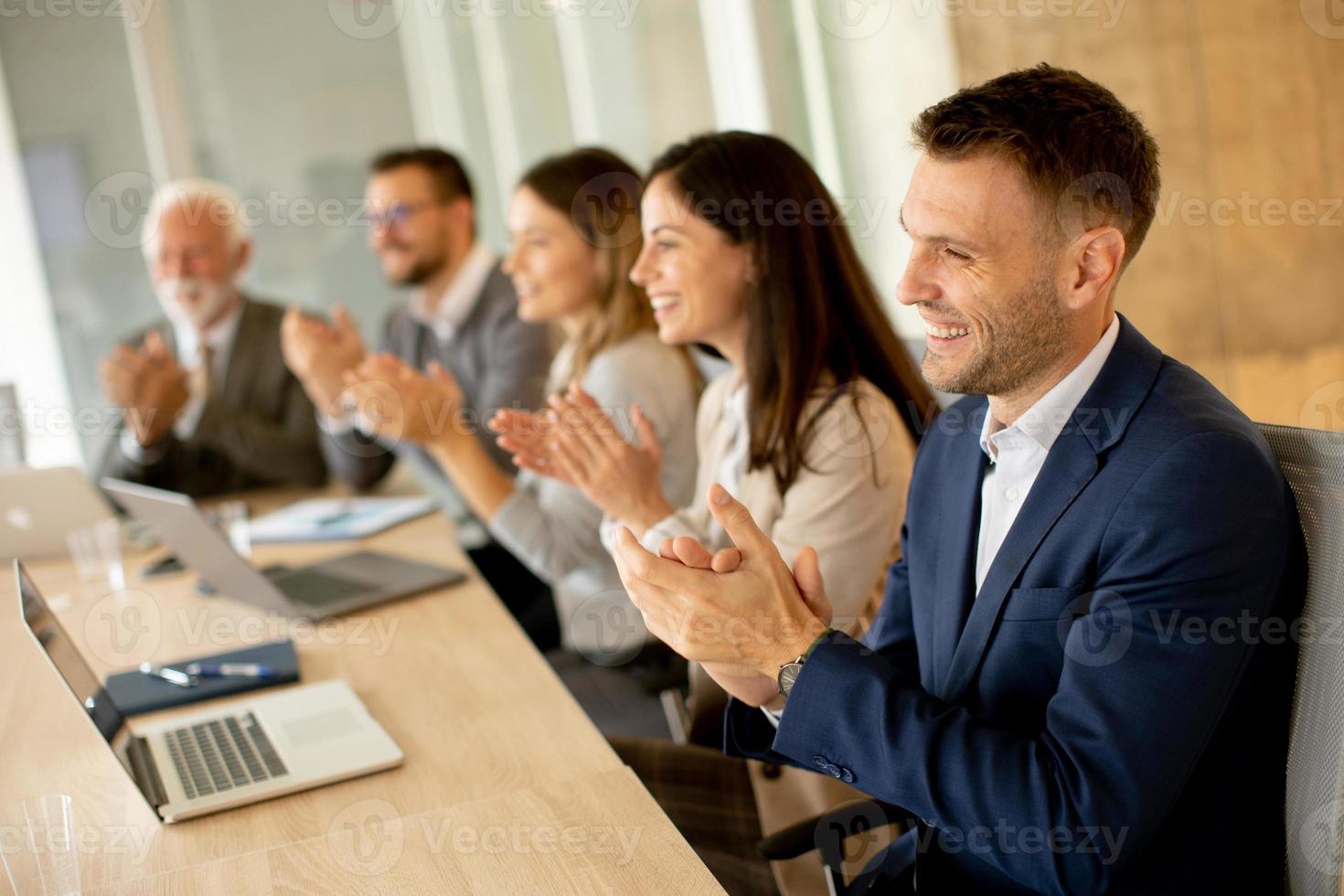 Satisfied proud business team clapping hands photo