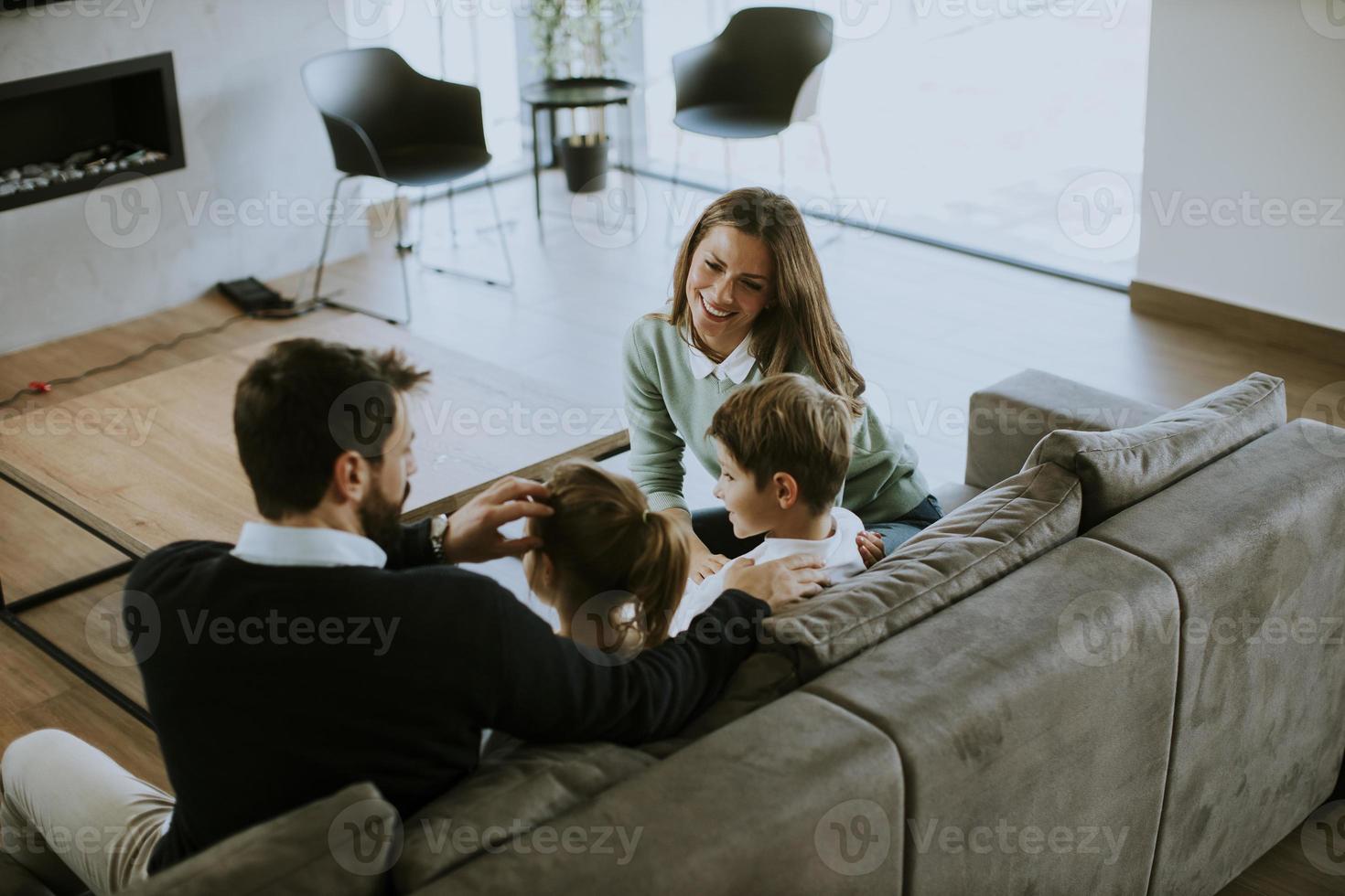 familia joven viendo la televisión juntos en el sofá de la sala de estar foto