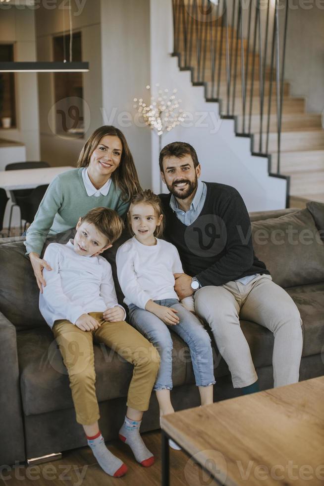 familia feliz con dos niños disfruta del tiempo juntos en el sofá en la sala de estar foto