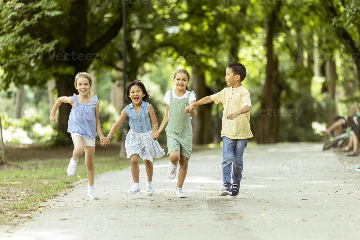 grupo de niños asiáticos y caucásicos divirtiéndose en el parque foto