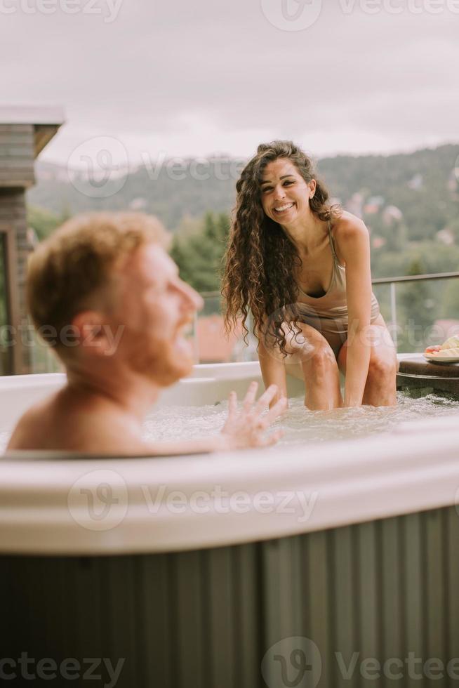 pareja joven disfrutando en el jacuzzi al aire libre de vacaciones 15708090  Foto de stock en Vecteezy