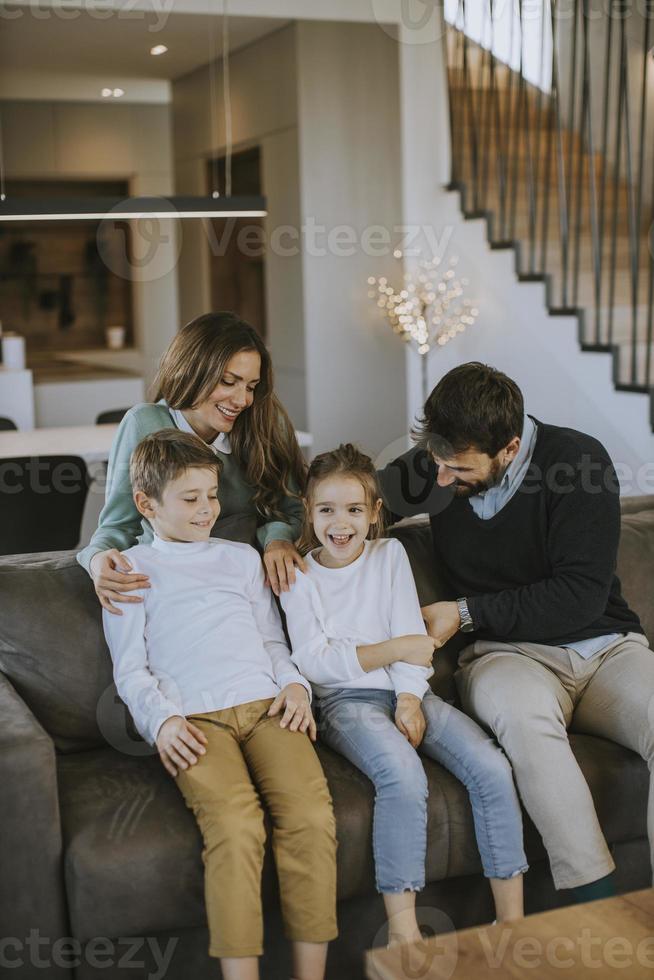 Happy family with two kids enjoy time together on couch in living room photo