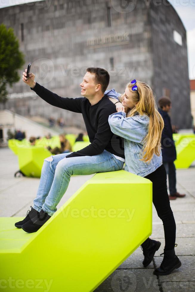 Young people using mobile phone on the bench in Vienna, Austria photo