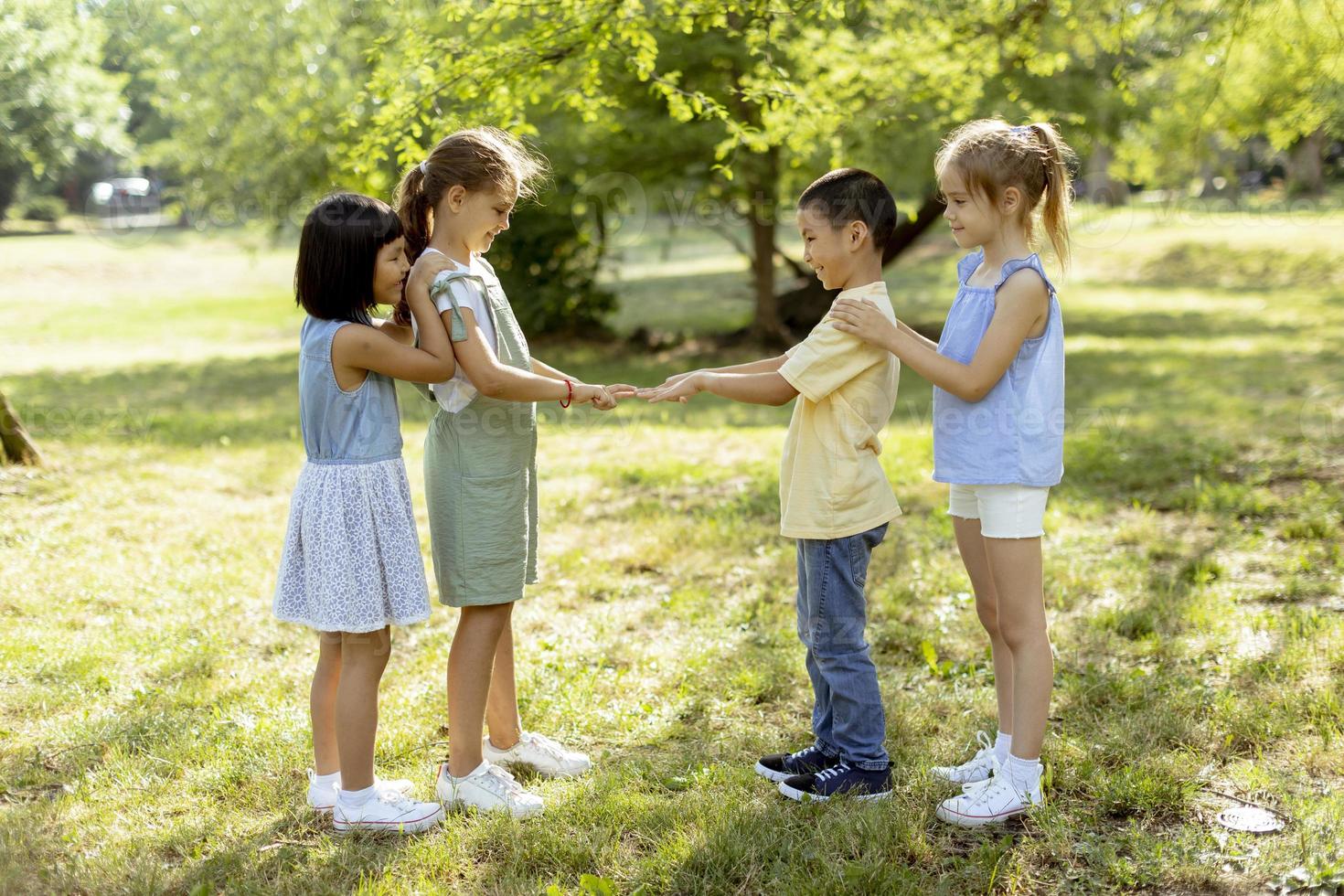 Group of asian and caucasian kids having fun in the park photo