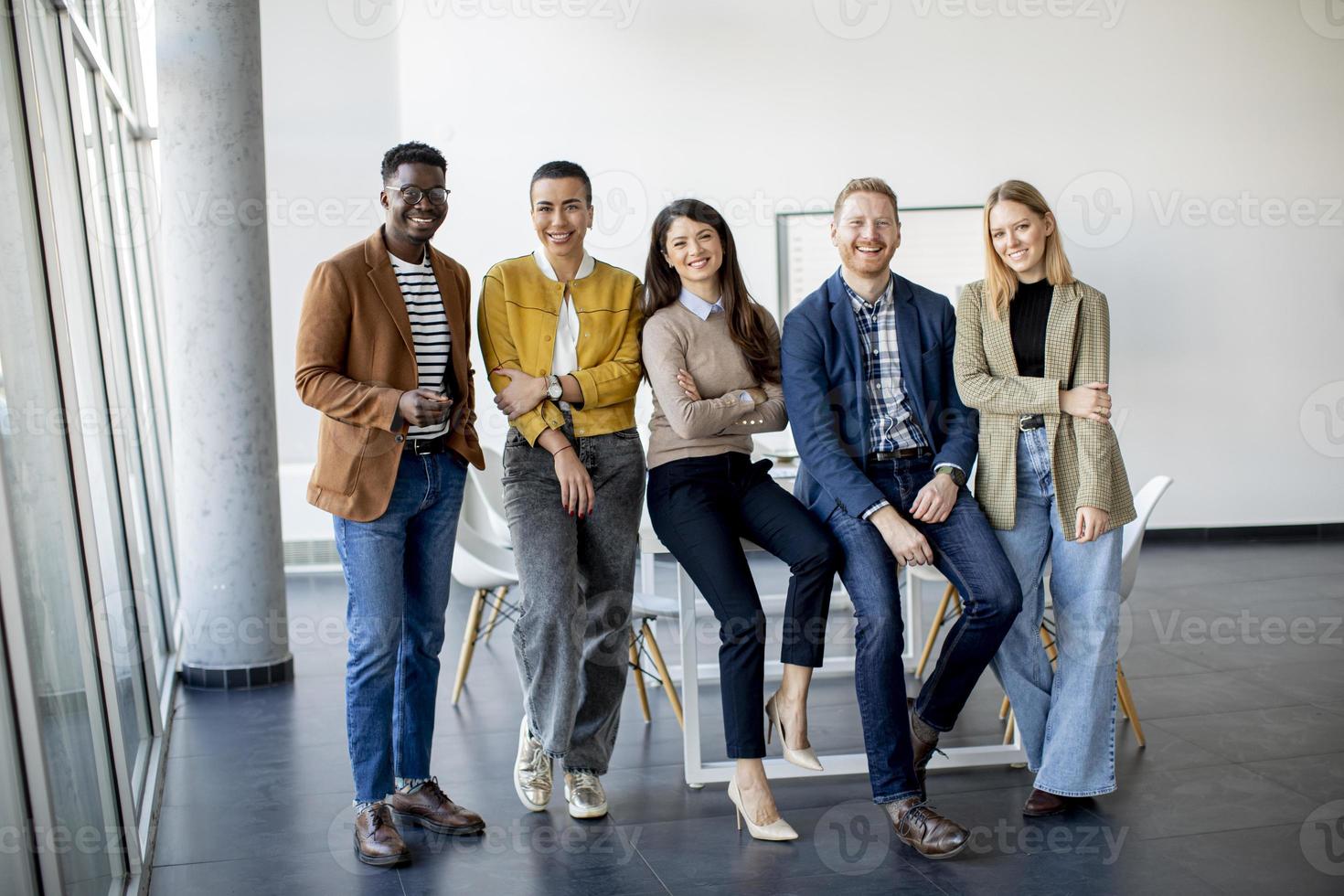 Group of positive businesspeople standing together in the office photo