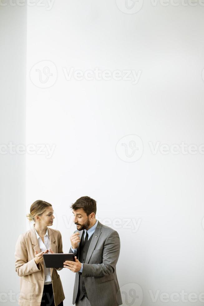 Young people with tablet by the wall in the office photo