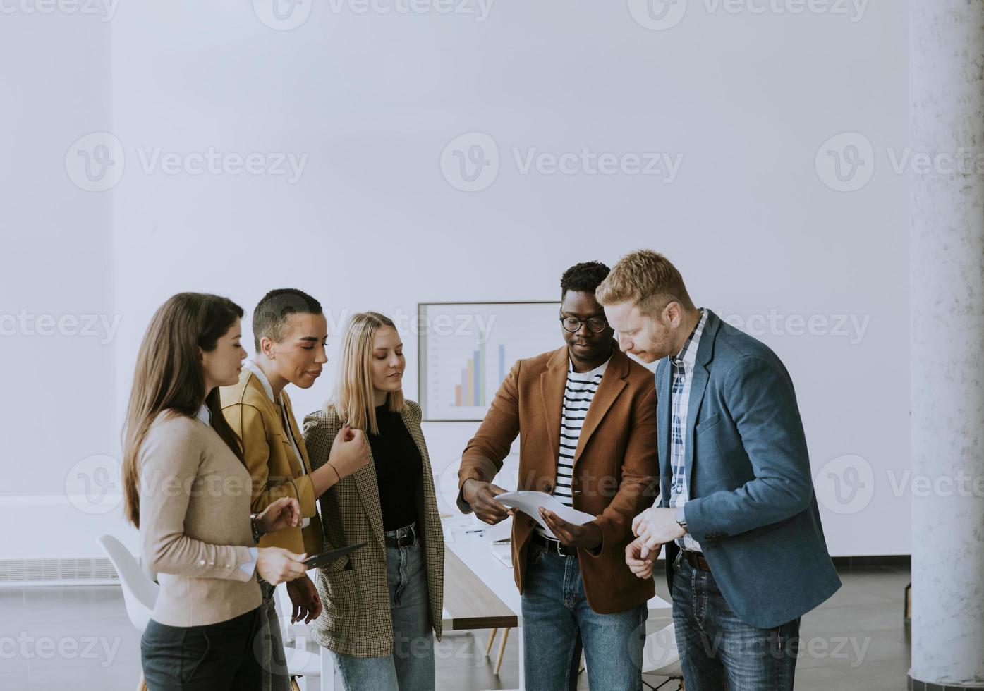 Group of multiethnic business people standing together and preparing new project on a meeting in office photo