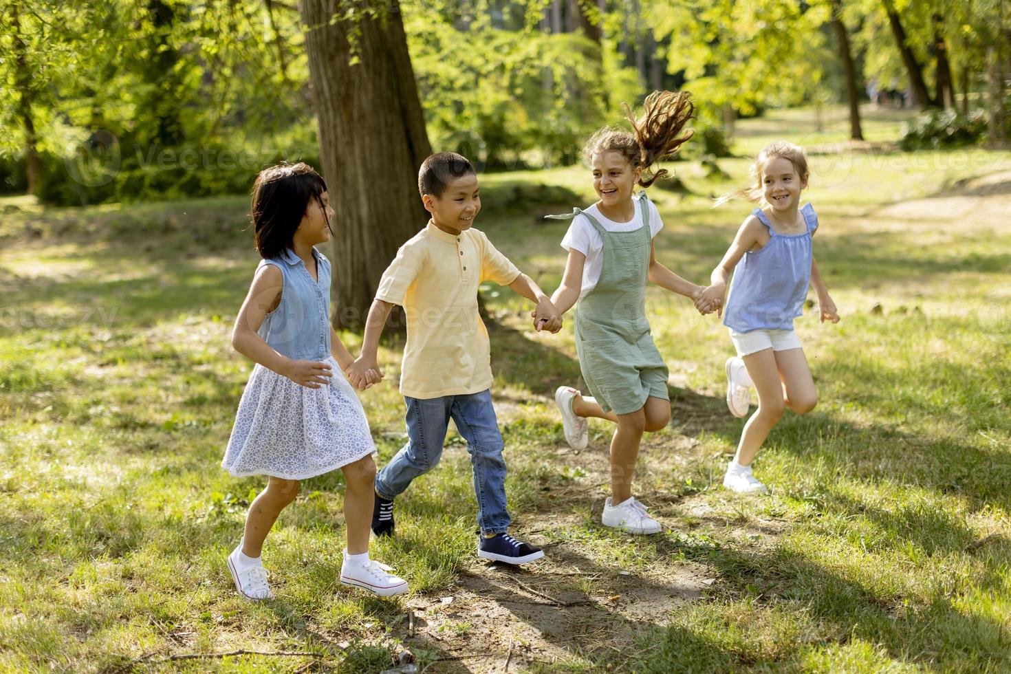 grupo de niños asiáticos y caucásicos divirtiéndose en el parque foto