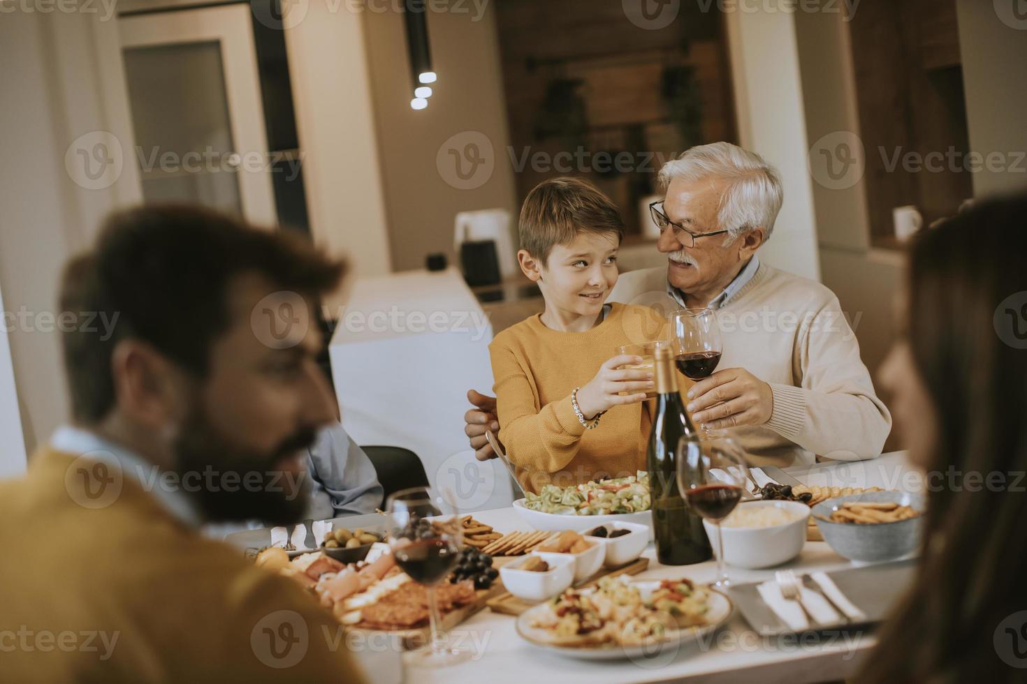 Happy family having dinner with red wine at home photo