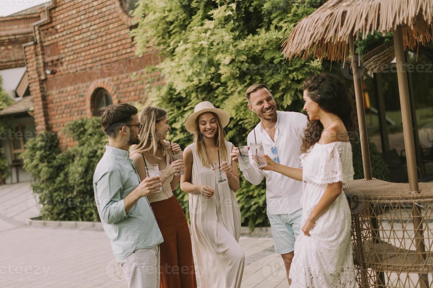 Group of young people cheering and having fun outdoors with drinks photo