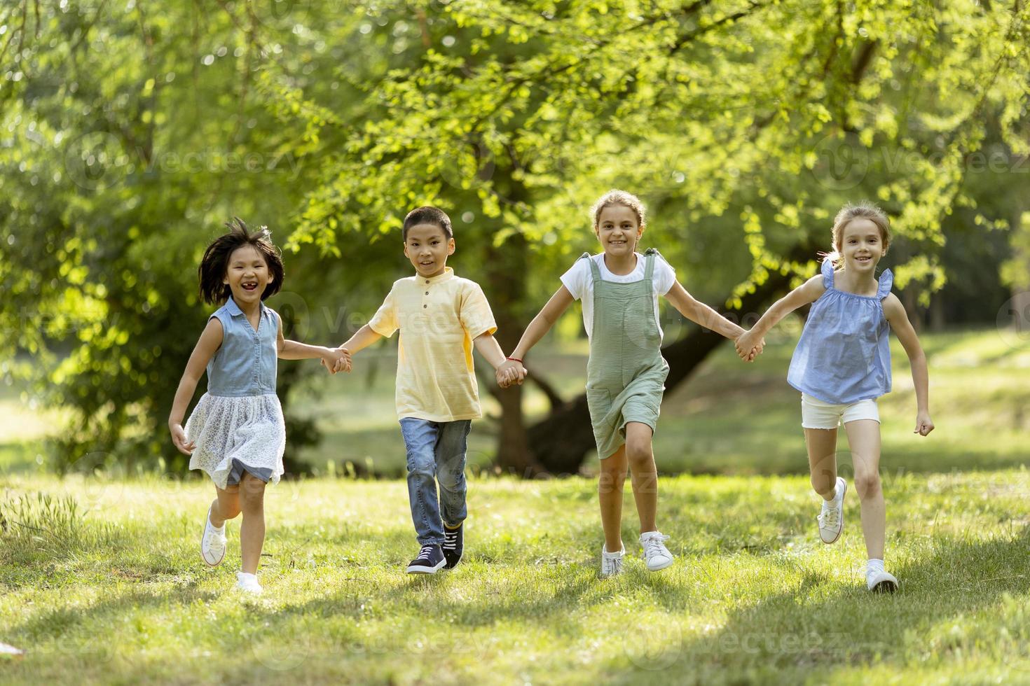 grupo de niños asiáticos y caucásicos divirtiéndose en el parque foto