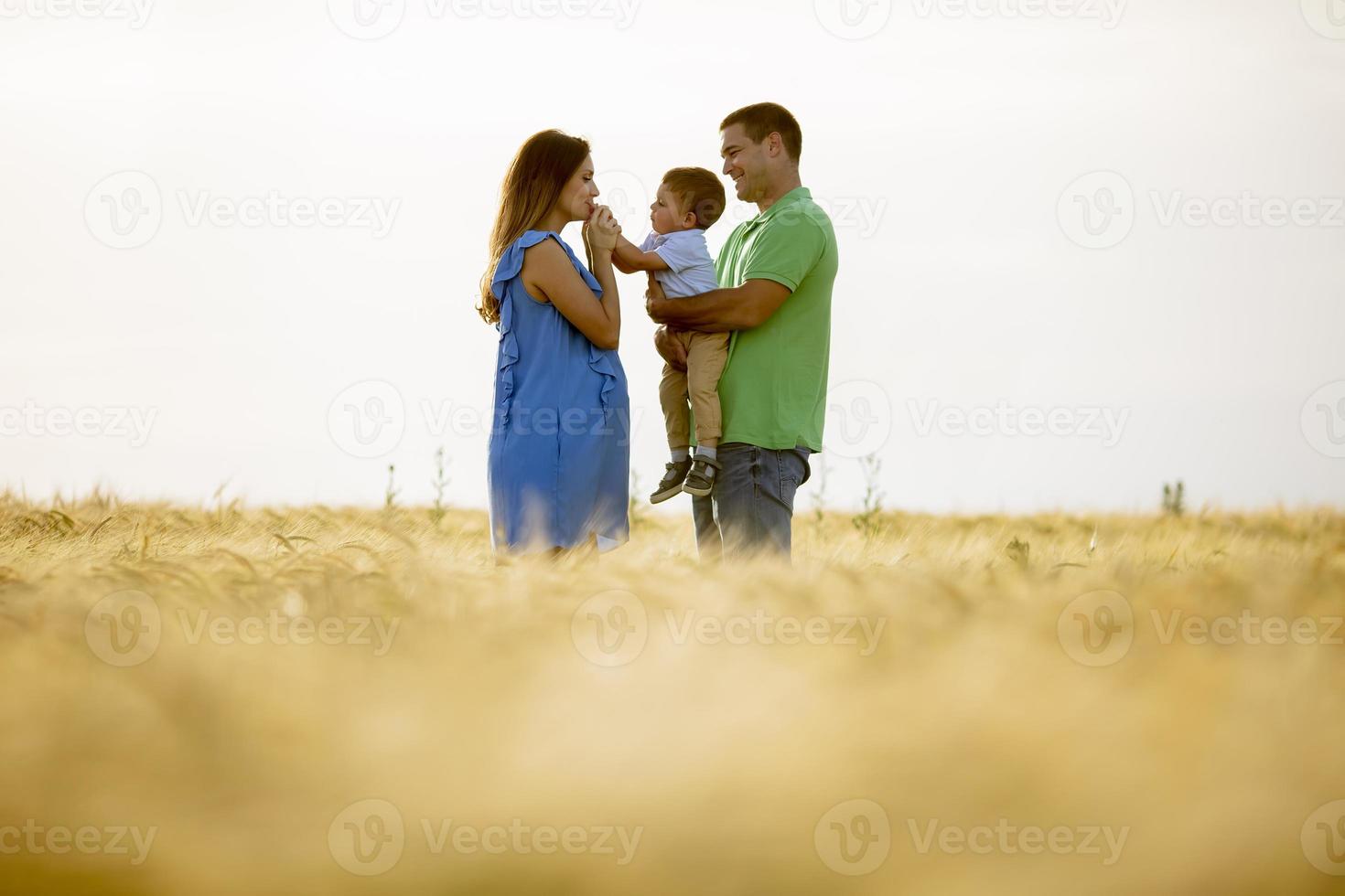 Familia joven con lindo niño divirtiéndose al aire libre en el campo foto