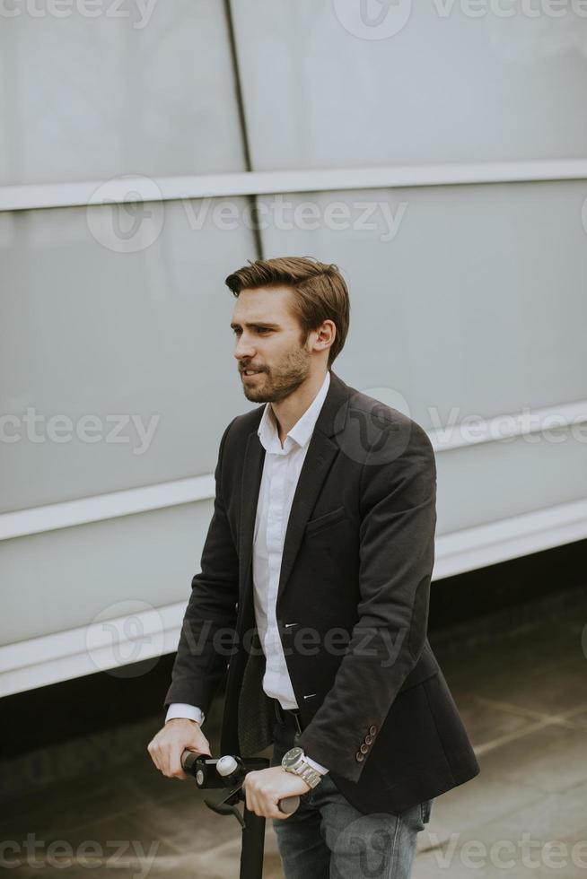 Young businessman riding electric scooter photo