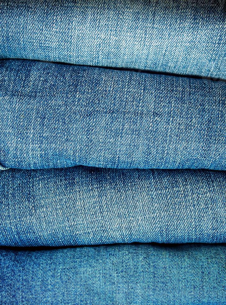 Pile of blue jeans, fabric texture photo