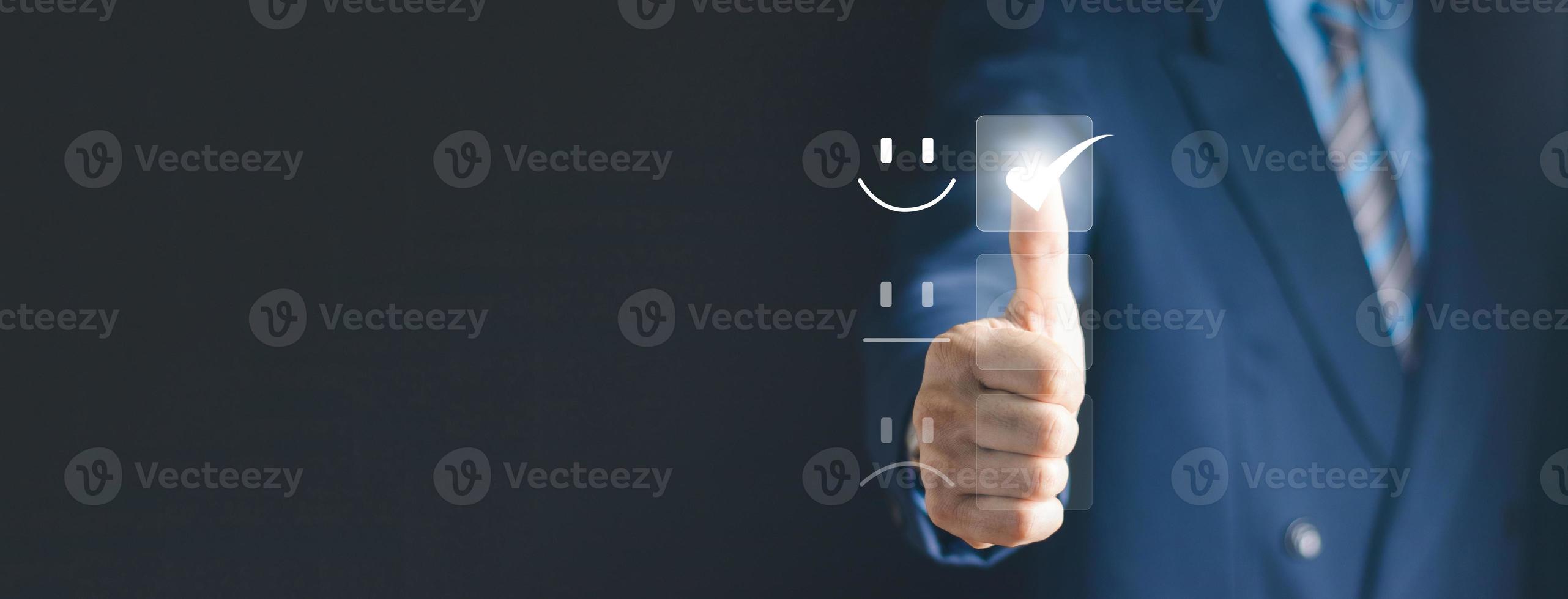 Customer Service and Satisfaction Concept Businessman is touching the virtual screen on the happy Smiley face icon to satisfy the service. Rating Very impressed. photo