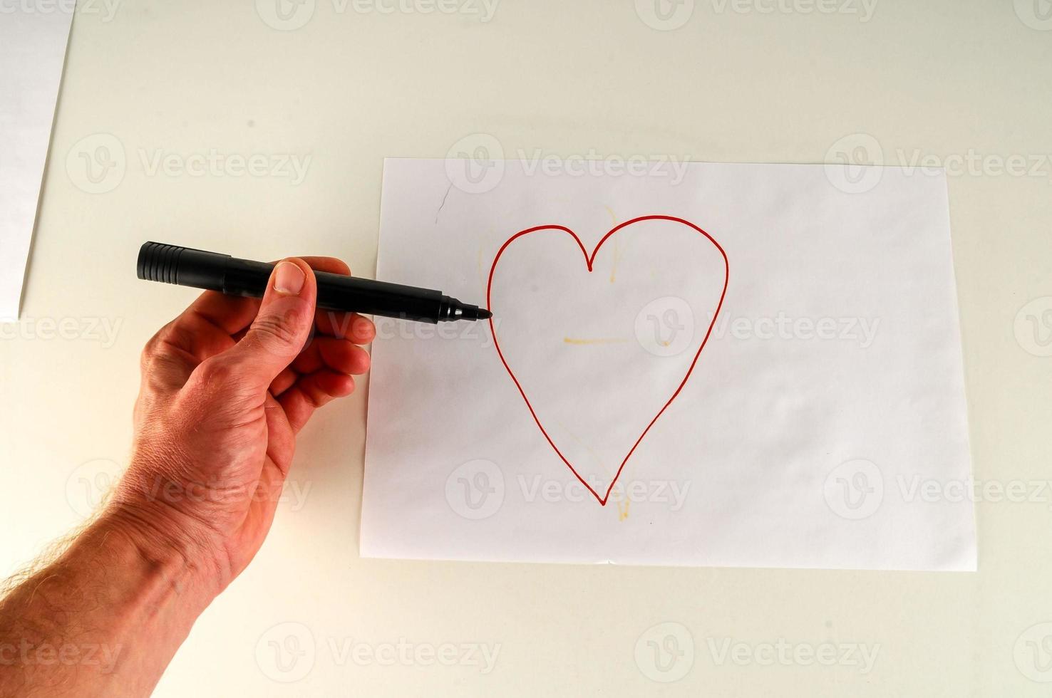 Hand drawing a heart on paper photo