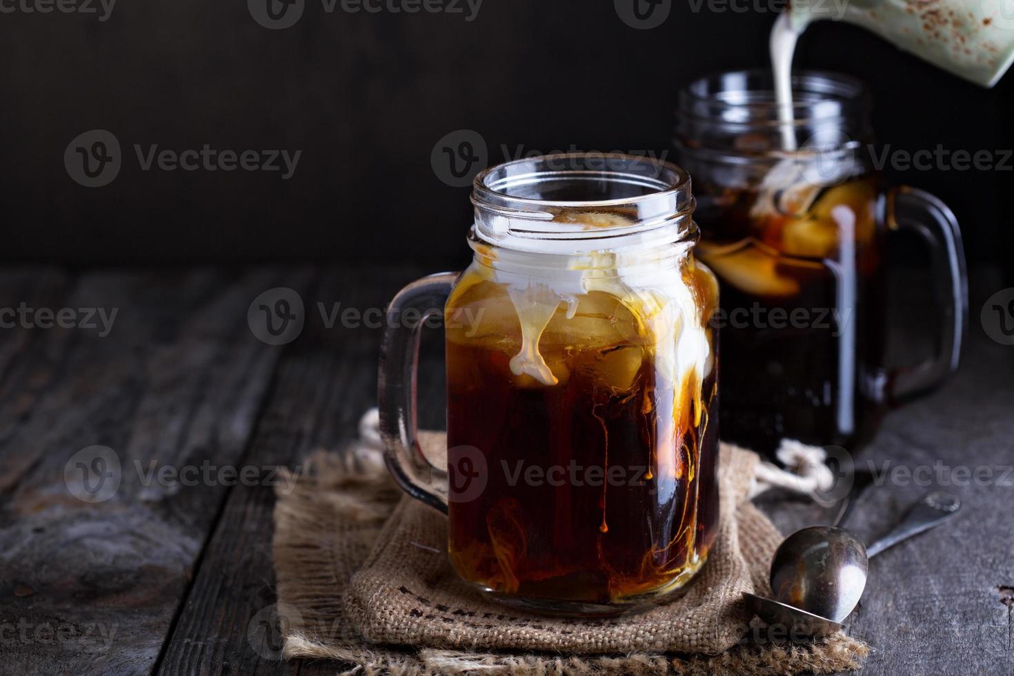 Iced coffee with milk in mason jars photo
