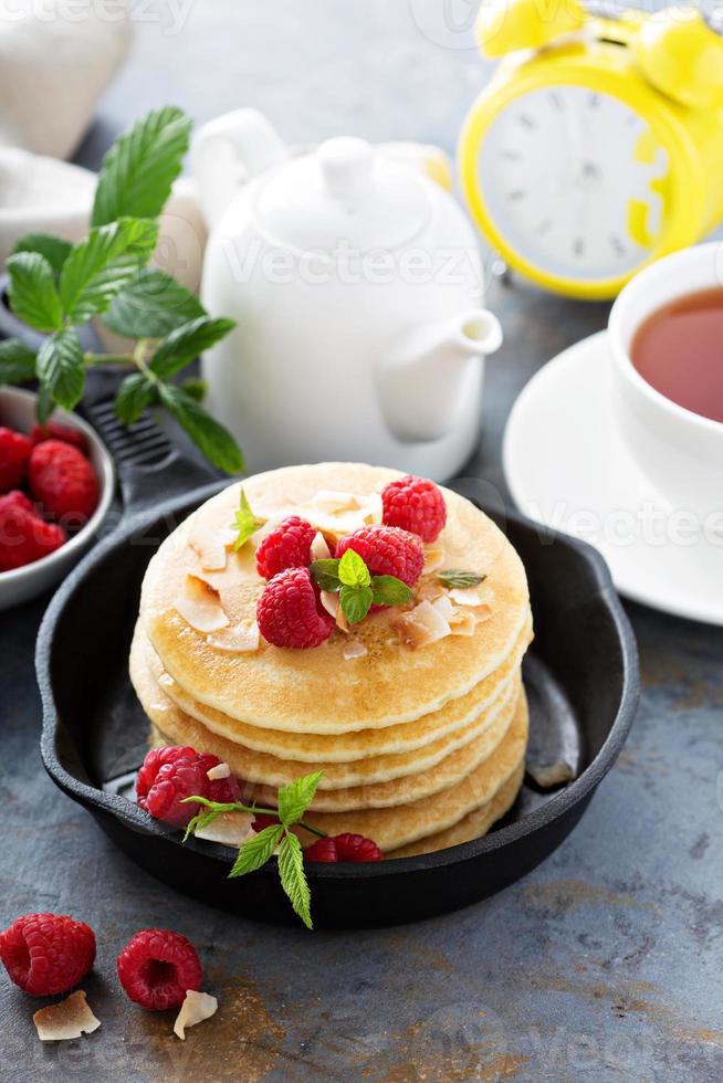 Stack of fluffy buttermilk pancakes with raspberry and coconut photo