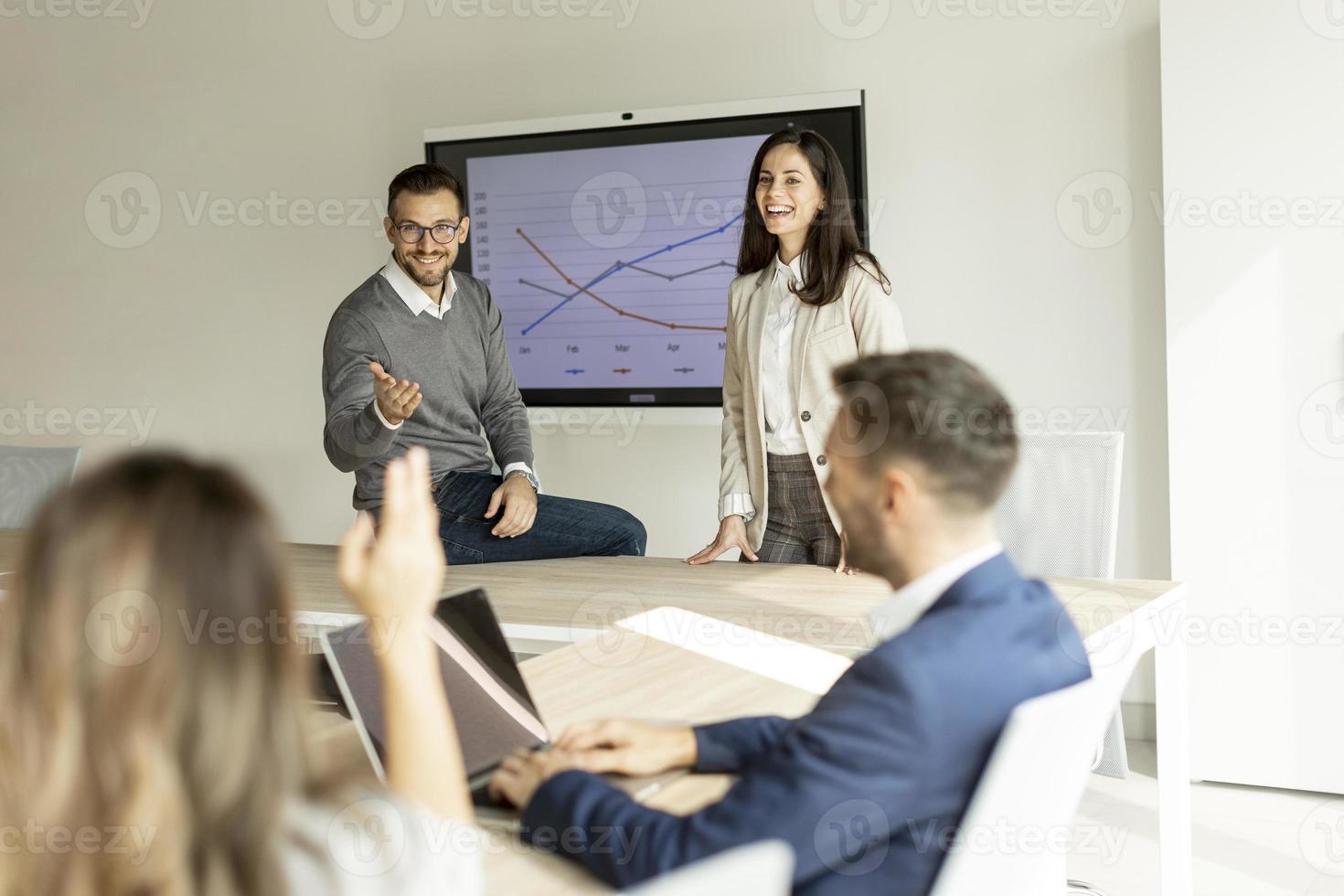 Young businesspeople presenting project strategy showing ideas on interactive whiteboard in office photo